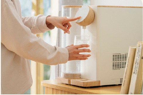 テーブルに置いたコトリスからグラスへ水を注ぐ様子